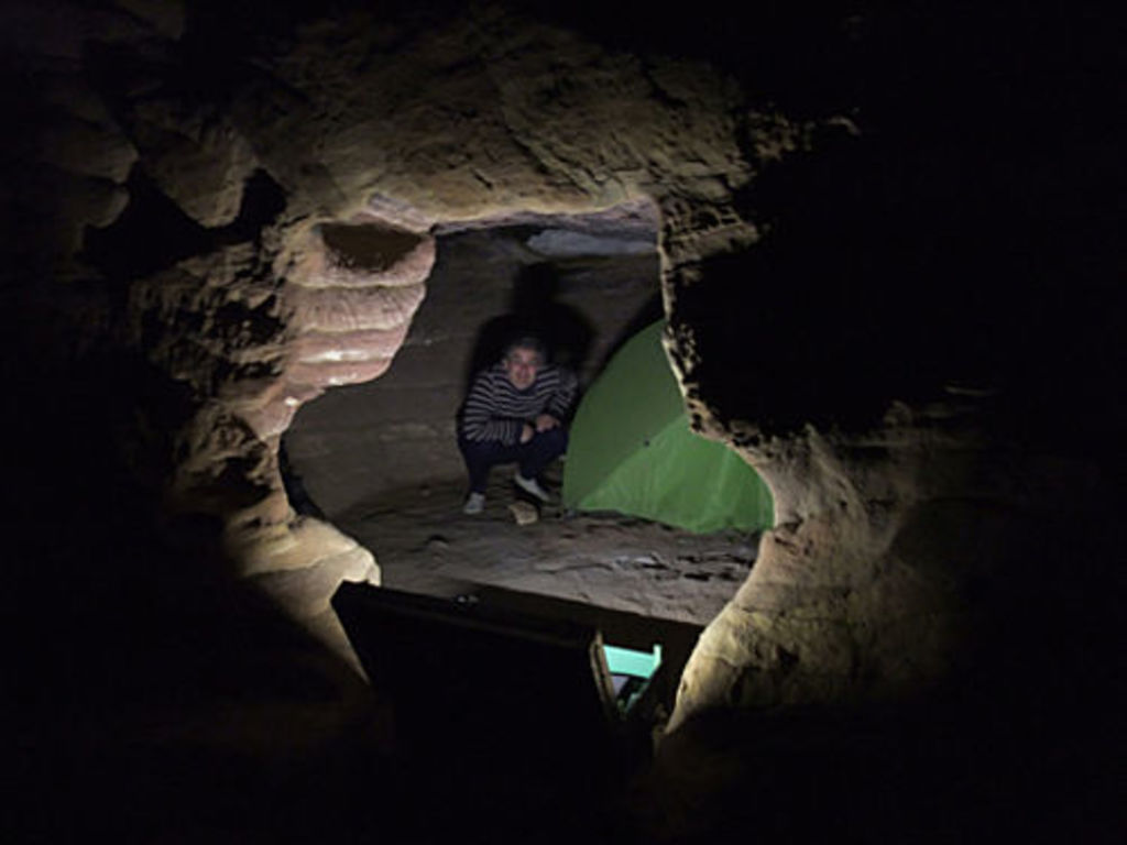 André Barmasse beside the tent in the rock cut tomb on top of Umm el-Biyara (photo: S. G. Schmid)