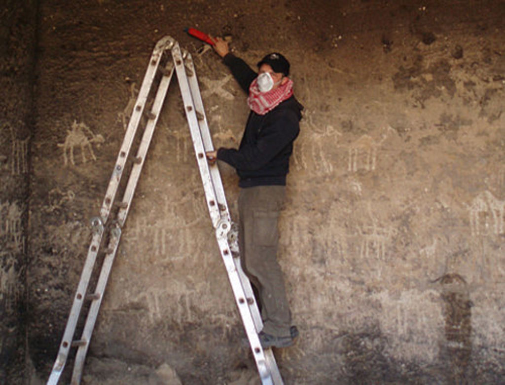 Marco Dehner cleaning the walls of inside the Aslah triclinium (photo: L. Gorgerat)