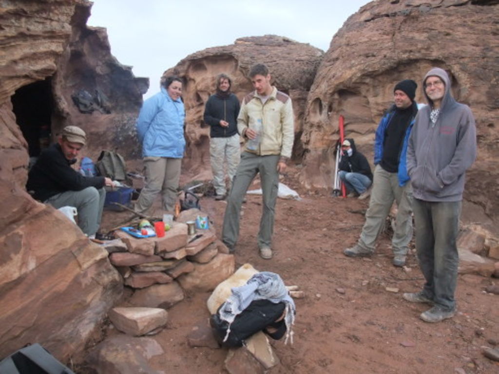 Fig. 36: The team of Umm el-Biyara wrapped up in winter clothes and warming up near the camp fire.